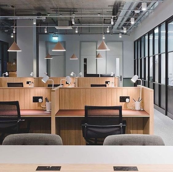 Members working at long wooden desks in the VoltCafé open-plan workspace in daylight